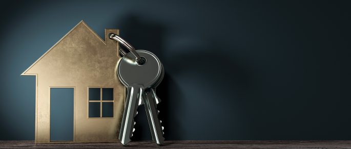 picture of keys and a house-shaped keychain against a blue background