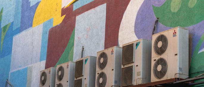 Old air conditioning units against blue and red graffiti background