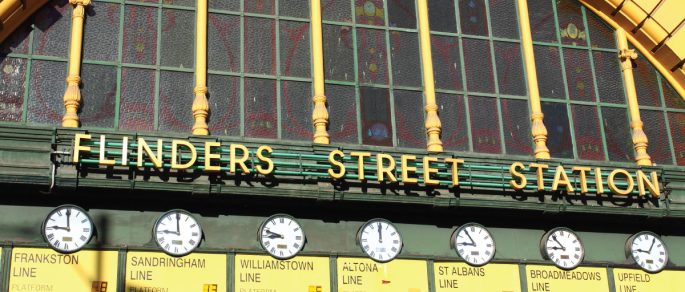 Facade of Flinders Street Station showing timetables of varied Melbourne train lines going to different suburbs