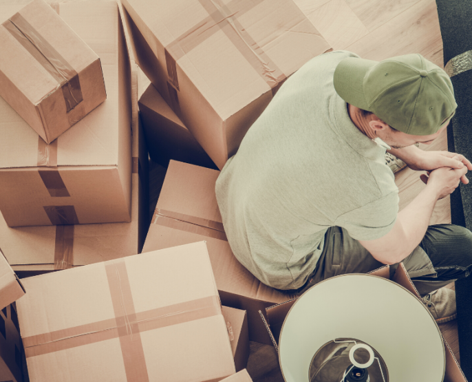 Man surrounded by moving boxes at the end of a tenancy in his rented home