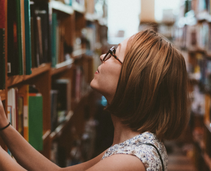 engaged woman searching through bookshelves