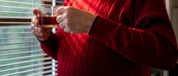 melancholic older male renter looking out window