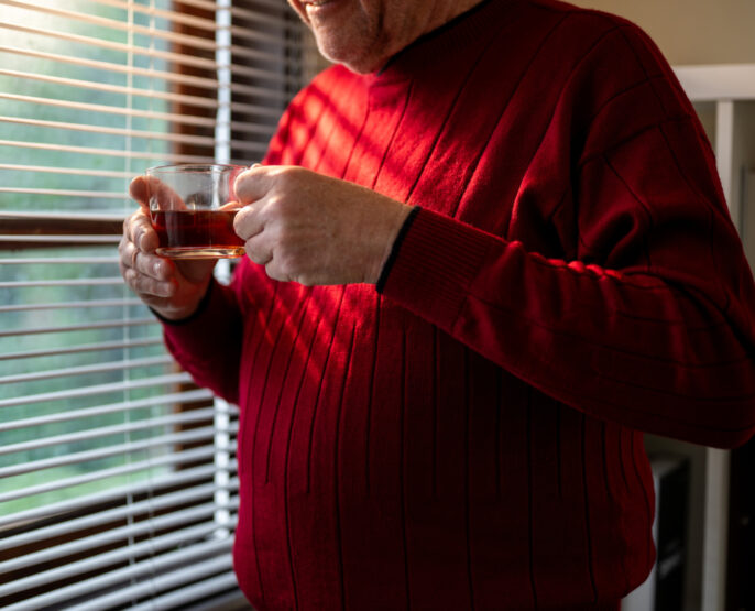 melancholic older male renter looking out window