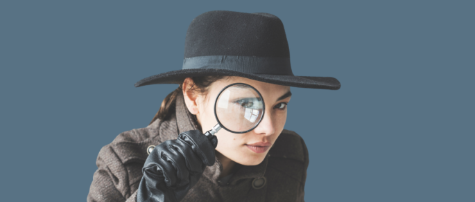 Detective looking through a magnifying glass